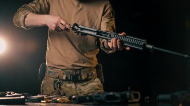 Profesyonel bir atış poligonunda profesyonel bir savaşçı bir NATO saldırı tüfeği kuruyor.