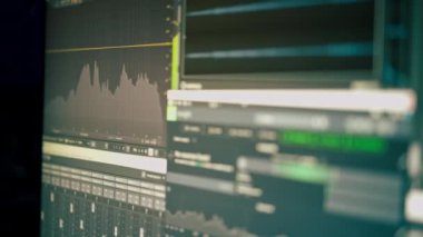Karanlık bir kayıt stüdyosunda ses kaydı, temizlik, karıştırma ve işleme sesi olan bir monitör profesyoneller için özel bir programda.