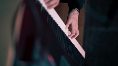 Dikey video kayıt odasında karanlık stüdyo ses mühendisi, istenen anahtarı seçen sentezleyicinin sesini dinlerken