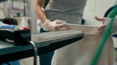 Profesyonel kuru temizlemeci kız beyaz ceketli profesyonel ekipmanında leke bırakıyor.