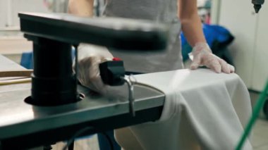 Profesyonel kuru temizlemeci kız beyaz cekette profesyonel ekipmanlara leke sürüyor.