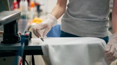 Profesyonel kuru temizlemeci kız beyaz cekette profesyonel ekipmanlara leke sürüyor.