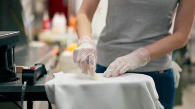 Profesyonel kuru temizlemeciyi kapat. Genç bir kız özel bir kimyasal kalemle lekeyi çıkarır.