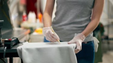 Profesyonel kuru temizlemeciyi kapat. Genç bir kız özel bir kimyasal kalemle lekeyi çıkarır.
