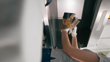 Profesyonel kuru temizlemeci kız ayakkabısındaki lekeyi çıkarıyor. Süet mükemmel durumda.