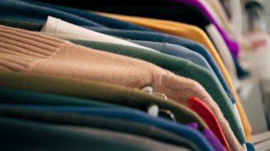 Askılarda farklı tekstil giysileri olan profesyonel kuru temizlemeciyi kapat.