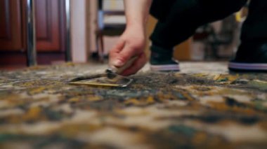 Daireyi kapat. Usta bir temizlikçi, yün kazıyıcı kullanarak halıyı temizler. Profesyonel bir temizlikçi.