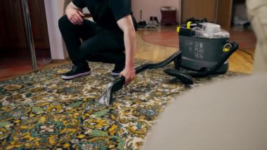 Apartmanın profesyonel temizliği. Temizlikçi kirden halıyı yıkar ve temizler.