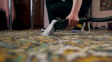 Apartmanın profesyonel temizliği. Temizlikçi kirden halıyı yıkar ve temizler.