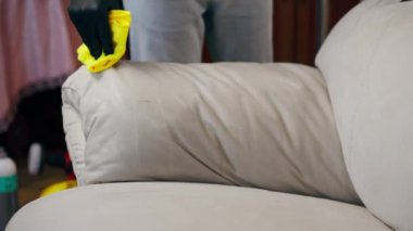 Kanepenin deri kısmını silmek için profesyonel bir temizleyiciyi kapat.