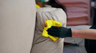 Kanepenin deri kısmını silmek için profesyonel bir apartman temizleyicisini kapat.