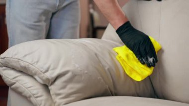 Kanepenin deri kısmını silmek için profesyonel bir temizleyiciyi kapat.