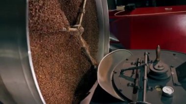 Bir kahve kızartma fabrikasının dikey video görüntüsü davul kavurucu bir kahvede.