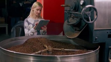 Kızartma fabrikasında profesyonel bir teftiş kahve kızartma işleminin kalitesini kontrol eder.