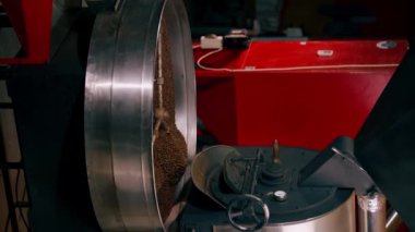 Bir kahve kızartma fabrikasının dikey video görüntüsü davul kavurucu bir kahvede.