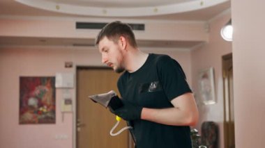 Daire temizleyicisinin profesyonel temizliği deterjan tekstil kanepesiyle süpürülüyor