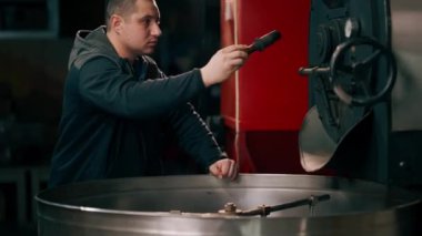 Kızartma fabrikasında kahve tutacağı. İçmeye hazır kahvenin rosto seviyesini kontrol ediyor.