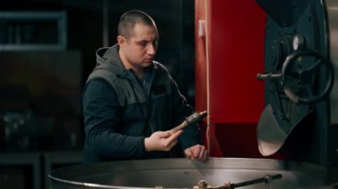 Kızartma fabrikasında kahve tutacağı. İçmeye hazır kahvenin rosto seviyesini kontrol ediyor.