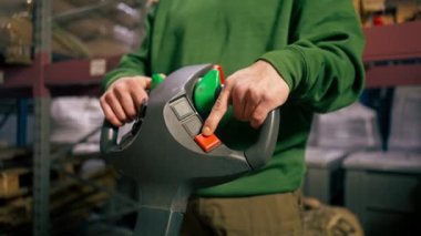 Bir kahve fabrikasında makineyi kontrol etmek için forklift kontrol paneli kullanan bir işçiye yakın çekim.