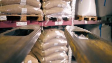 Bir kahve fabrikasında, kameradan çatal çıkan bir işçinin paleti kapmak için yakın plan fotoğrafı.