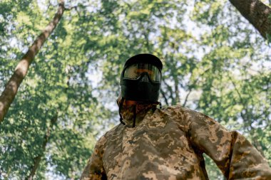 Ormanda, sahanın ortasında langırt oynamak için üniformalı bir oyuncu yarışmaya hazır genç bir adam.