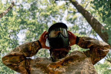 Ormanda, sahanın ortasında langırt oynamak için üniformalı bir oyuncu yarışmaya hazır genç bir adam.