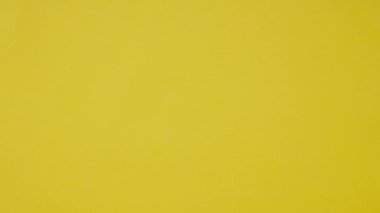 Gölgeleri olmayan sarı, sıcak bir arka plan. Erkek eli, renkli kelimelerle ahşap küpler döşedi endüstriyi.