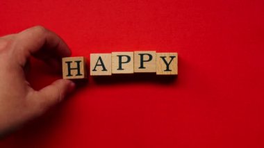 Gölgeleri olmayan kırmızı, sıcak bir arka plan. Erkek eli renkli sözlerle ahşap küpler seriyordu.