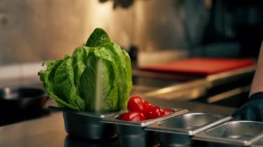 Profesyonel bir mutfakta, Yunan salatasının tüm malzemeleri demir bir masanın üzerinde.