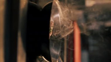 Profesyonel bir mutfakta bir parça tavuk filetosu küçük bir tavada kızartılır.