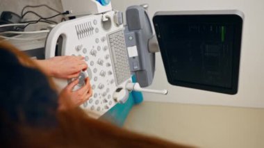 Klinikteki jinekolojik ofis ultrason makinesinin dikey görüntüsü doktor analiz eder ve kaydeder.