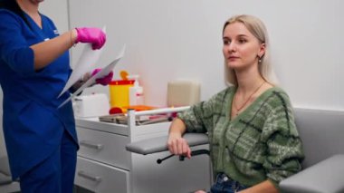 Analiz odasındaki özel bir klinikte doktor, aşıyla ilgili bir belgeyi hastaya verir.