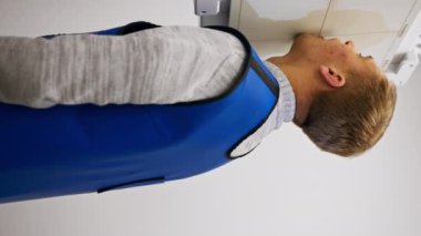 Beyaz röntgen odasındaki özel bir klinikteki dikey video bir prosedüre hazırlanır.