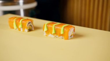 Japon lokantasına yakın çekim. Avokado dilimli hazır balık. Suşi servis etmeye hazır.