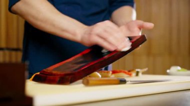 Bir Japon restoranında şef geleneksel bir deniz ürünleri restoranında servis edilen tabağı siler.