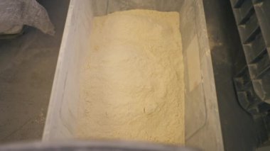 Un kırmızı bir kepçeden plastik bir kaba nasıl dökülüyor?