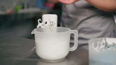 Profesyonel bir mutfakta kadın bir fırıncıyı mikserle karıştırma kremi ile yakın plan.