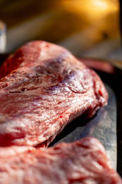 Demirden bir masanın üzerindeki restoranda, terbiye için hazırlanan taze etle birlikte profesyonel yemekler var.