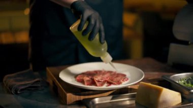 Merkezdeki Ribs Bar 'da siyah eldivenli sarı ışıkçı şefi beyaz bir tabağa yağ döker.