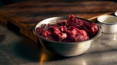 Demir bir kasenin üzerinde bir restoranın dikey görüntüsü var. Salamura şefi için hazırlanan taze etle birlikte profesyonel yemekler var.