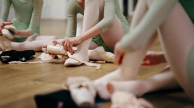 Profesyonel çocuk bale okulunu kapatın. Balerinler yerde otururken sivri ayakkabılar giyin.