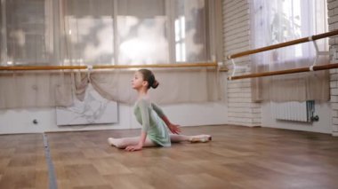 Açık yeşil vücutlu küçük bir kızın solo dans provası için profesyonel bale okulu