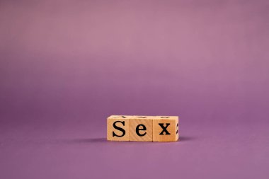 Siyah harfli, gölgeli tahta küplerle mor, sıcak bir arkaplan ve seksten harflerle yazılmış kelimeler.