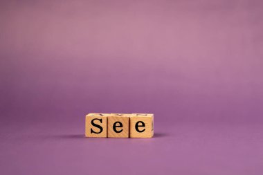 Siyah harfli, gölgeli ahşap küplerle mor, sıcak bir arka plan.