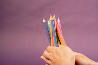 Mor, sıcak arka plan, gölgeli kadın. Mutlu çocukluk resimleri çizmek için renkli kalemler. Pederin rengini seç.