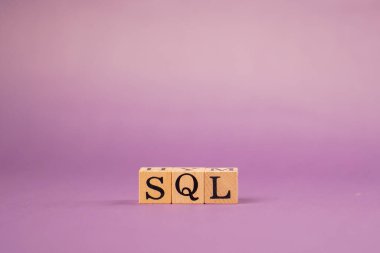 Siyah harfli ve gölgeli tahta küplerle mor, ılık bir arkaplan ve SQL harflerinden sözcükler.