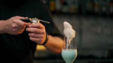 Erkek barmenin üzerine döktüğü lezzetli köpüklü kokteyl. Etrafta bir sürü damla var.