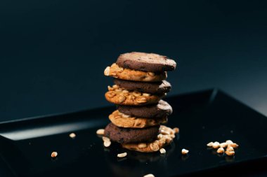 Piramit şeklinde tatlı bir mutfak fındığı içine yerleştirilmiş siyah ve mavi düz bir plaka üzerine dizilmiş.