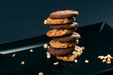 Piramit şeklinde tatlı bir mutfak fındığı içine yerleştirilmiş siyah ve mavi düz bir plaka üzerine dizilmiş.