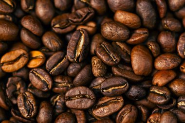 Siyah-mavi arka planda yakın plan kahve çekirdekleri kalp şeklinde hazır. 